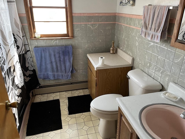 W6011 Pike River Rd, Wausaukee, WI 54177 - full bathroom featuring baseboard heating, toilet, tile walls, vanity, and tile patterned flooring