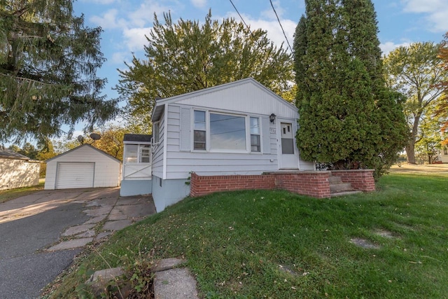 view of front of home featuring a front yard, a garage, and an outdoor structure