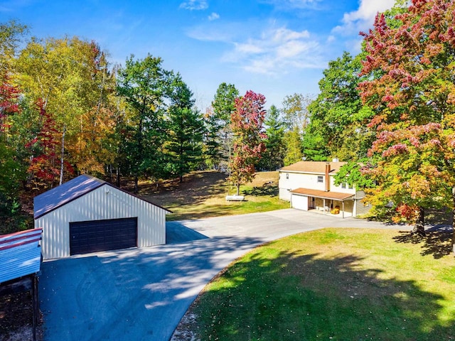 exterior space featuring a front yard, a garage, and an outbuilding