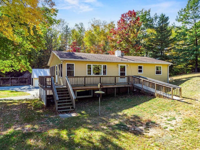 rear view of house featuring a storage shed, a yard, and a wooden deck