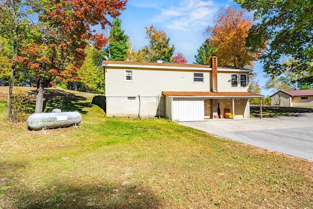 exterior space with a garage, a carport, and a lawn