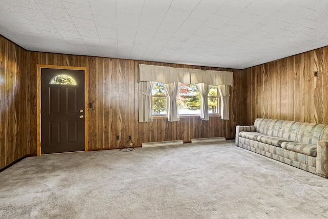 unfurnished living room featuring carpet floors, a baseboard heating unit, and wooden walls