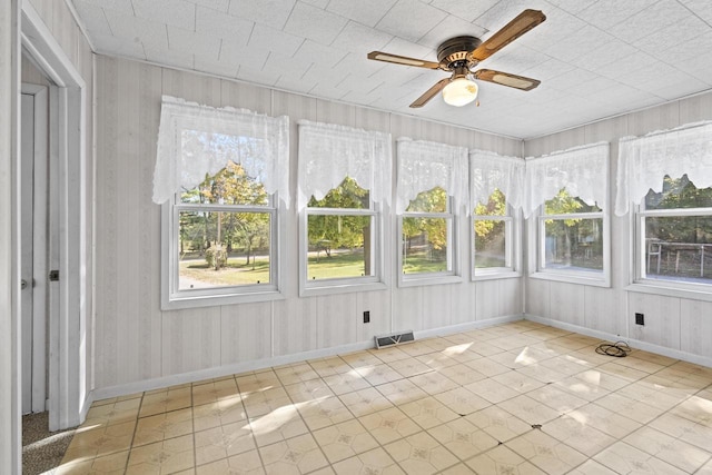 unfurnished sunroom with ceiling fan