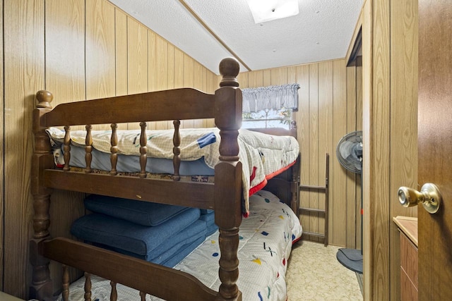 bedroom with a textured ceiling and wood walls