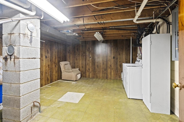 basement featuring wooden walls and separate washer and dryer