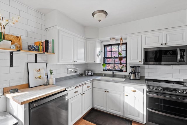 kitchen with decorative backsplash, light hardwood / wood-style flooring, stainless steel appliances, sink, and white cabinetry