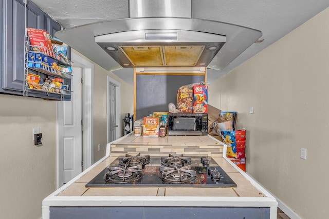 kitchen with island range hood, black gas stovetop, and backsplash