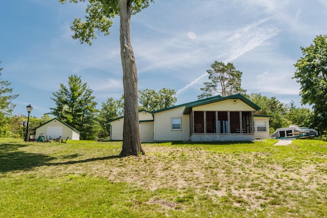 rear view of property featuring a yard and a sunroom