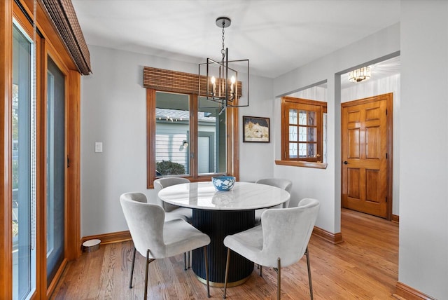 dining space featuring light hardwood / wood-style floors and an inviting chandelier