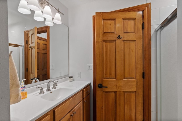 bathroom with a shower with door, vanity, and a chandelier