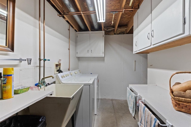 clothes washing area featuring washing machine and clothes dryer and cabinets