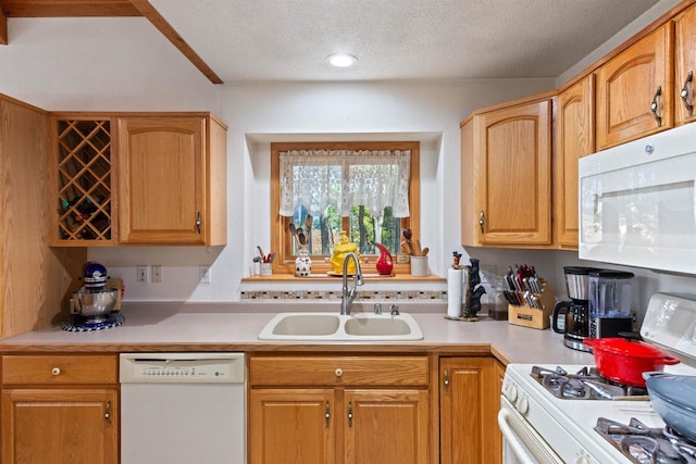 kitchen with a textured ceiling, sink, and white appliances