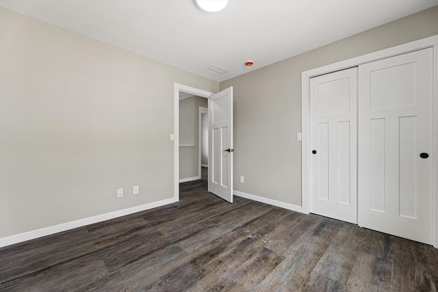 unfurnished bedroom with a closet and dark hardwood / wood-style flooring