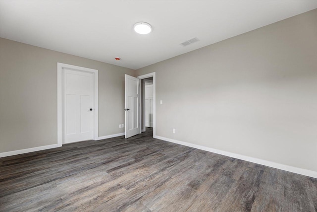 unfurnished room with dark wood-type flooring