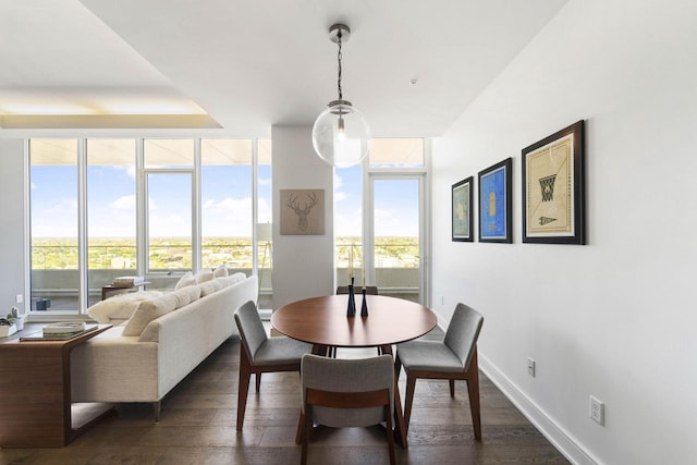 dining area featuring dark wood-style floors, baseboards, and a wall of windows