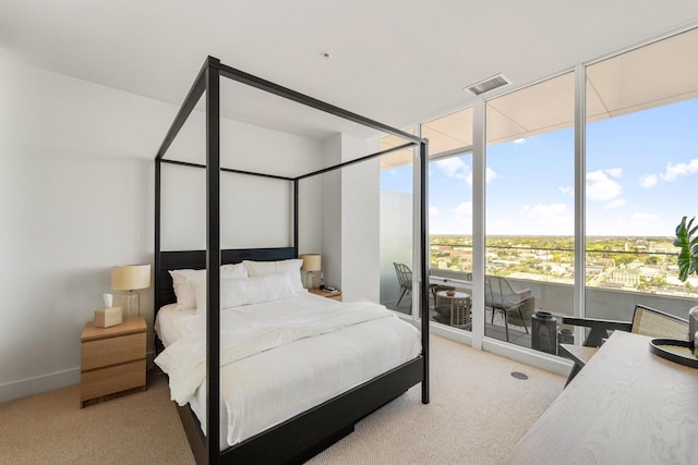 bedroom featuring light carpet, expansive windows, visible vents, and baseboards