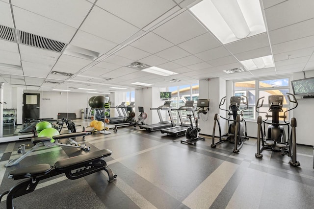 workout area featuring a wealth of natural light, visible vents, and a paneled ceiling