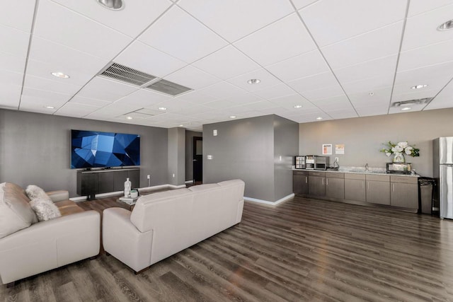 living room featuring a paneled ceiling, dark wood-style flooring, baseboards, recessed lighting, and visible vents