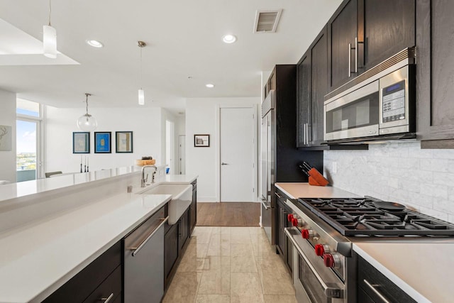 kitchen featuring visible vents, decorative light fixtures, light countertops, appliances with stainless steel finishes, and decorative backsplash