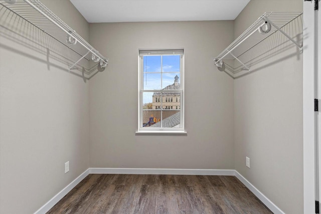 walk in closet with dark wood-type flooring