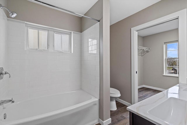 full bathroom with vanity, tiled shower / bath combo, hardwood / wood-style flooring, and toilet