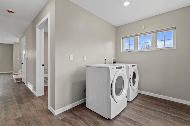 laundry area featuring washing machine and dryer and dark hardwood / wood-style floors