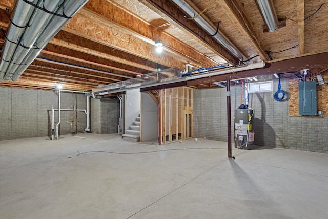 basement featuring brick wall, electric panel, and water heater