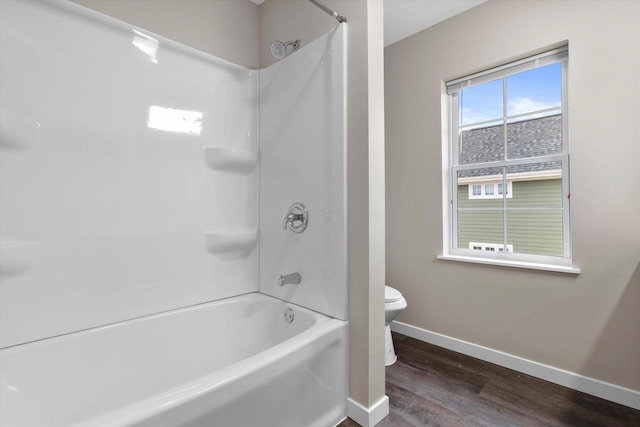 bathroom featuring hardwood / wood-style floors, bathing tub / shower combination, and toilet