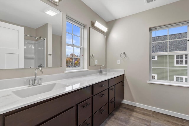 bathroom with vanity, a shower, wood-type flooring, and a wealth of natural light