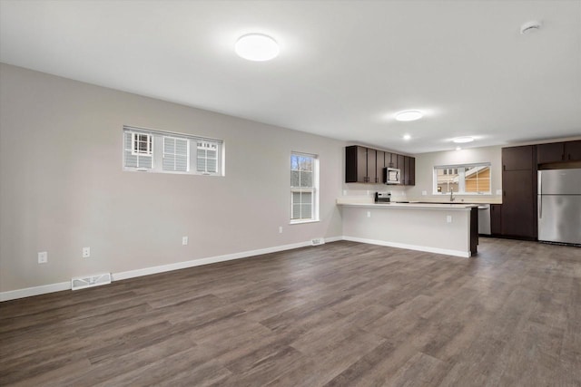 unfurnished living room with wood-type flooring and sink