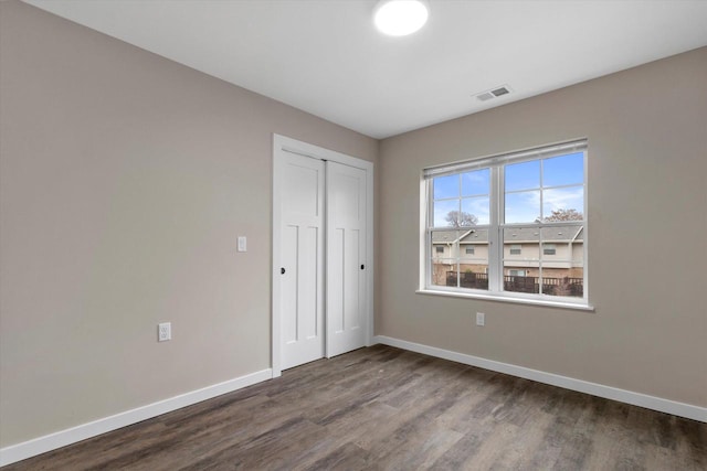 unfurnished bedroom featuring wood-type flooring and a closet