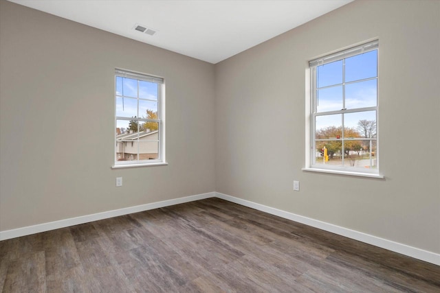 spare room featuring plenty of natural light and hardwood / wood-style floors