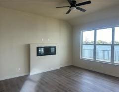 unfurnished living room with ceiling fan, vaulted ceiling, and dark hardwood / wood-style flooring