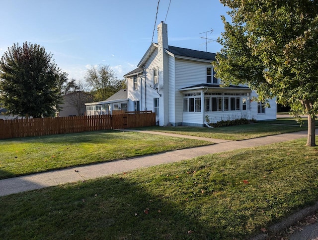 exterior space with a sunroom and a lawn