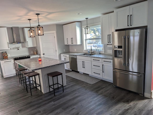 kitchen with wall chimney range hood, appliances with stainless steel finishes, and white cabinetry