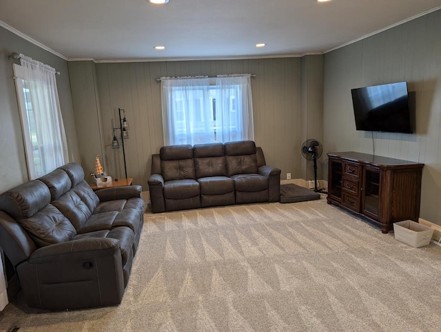 carpeted living room featuring crown molding and wood walls