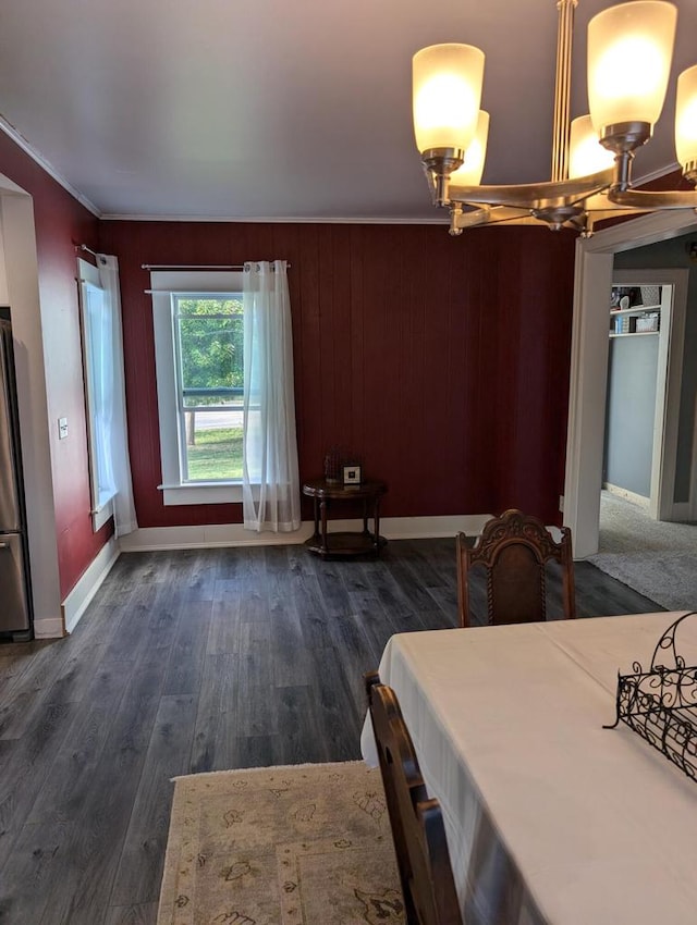 dining area featuring ornamental molding, wood walls, and dark hardwood / wood-style floors