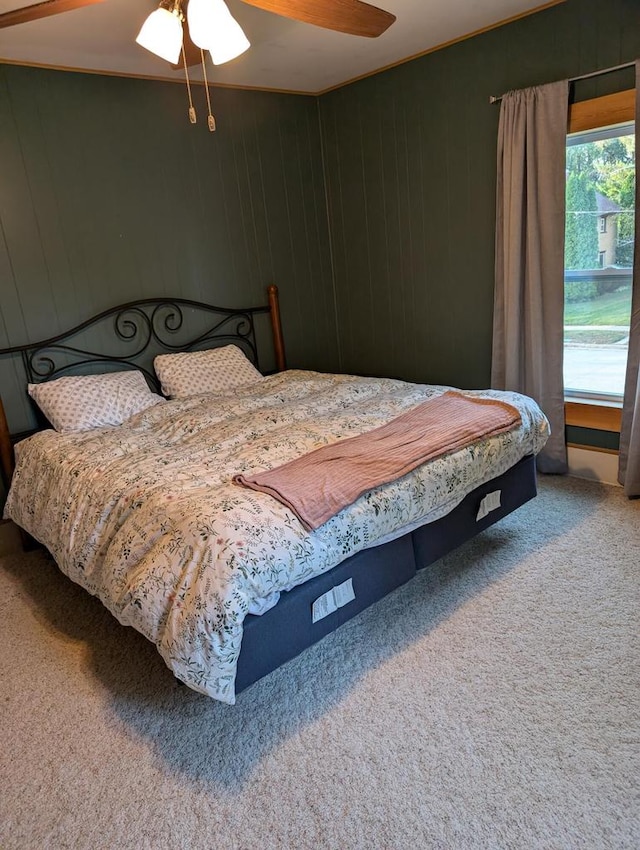 bedroom with ceiling fan, ornamental molding, and carpet