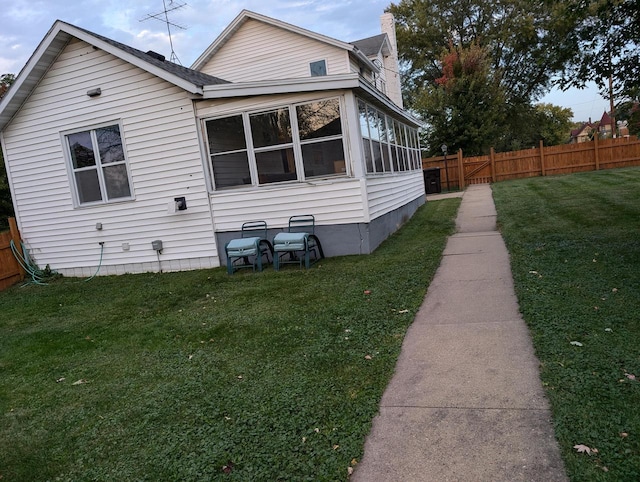 view of property exterior featuring a yard and a sunroom