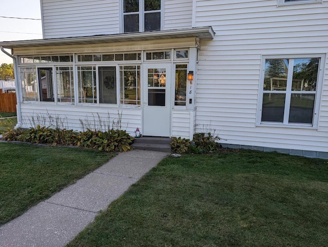 view of exterior entry with a lawn