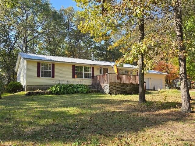 ranch-style home with a deck and a front lawn