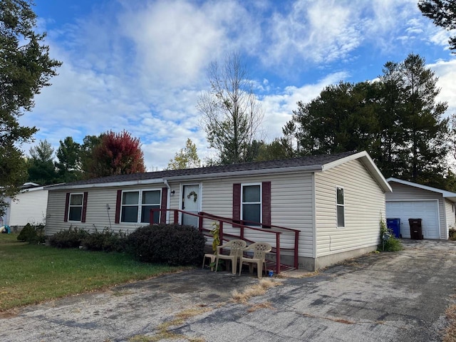 manufactured / mobile home with an outbuilding, a front yard, and a garage