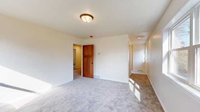 carpeted spare room featuring a wealth of natural light