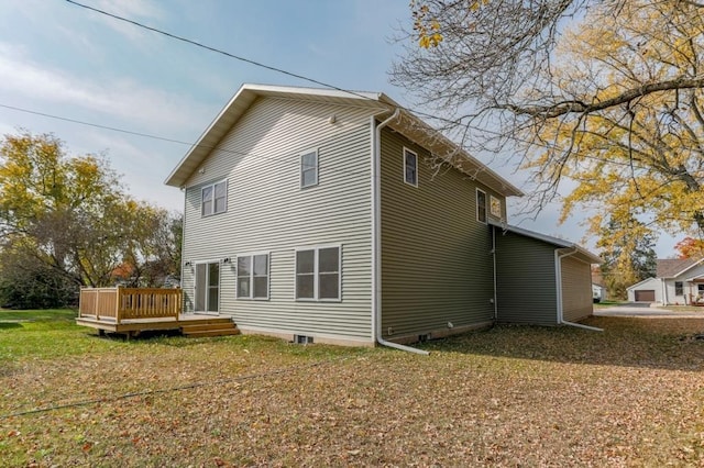 back of house featuring a lawn and a deck