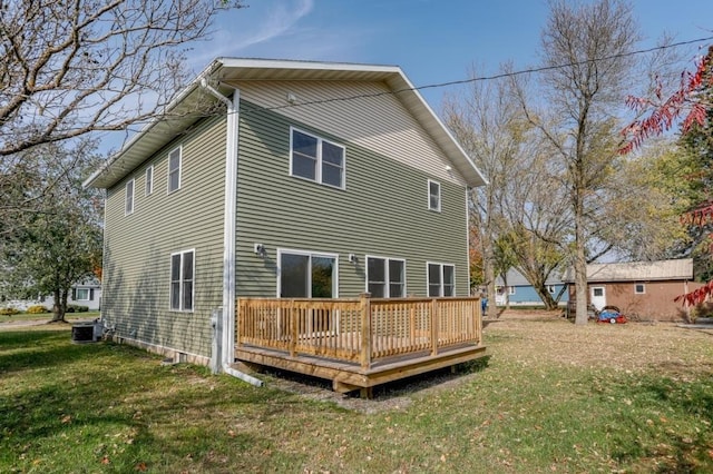 back of house with a lawn, a deck, and central AC