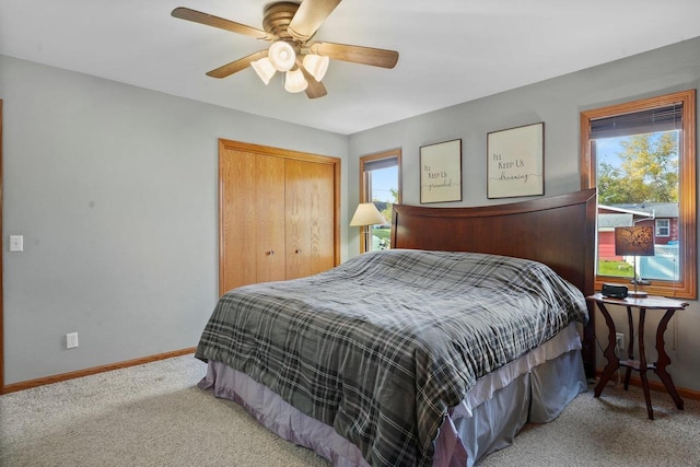 carpeted bedroom featuring ceiling fan and a closet