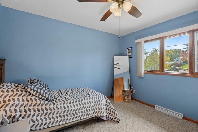 bedroom with ceiling fan, a baseboard heating unit, and carpet