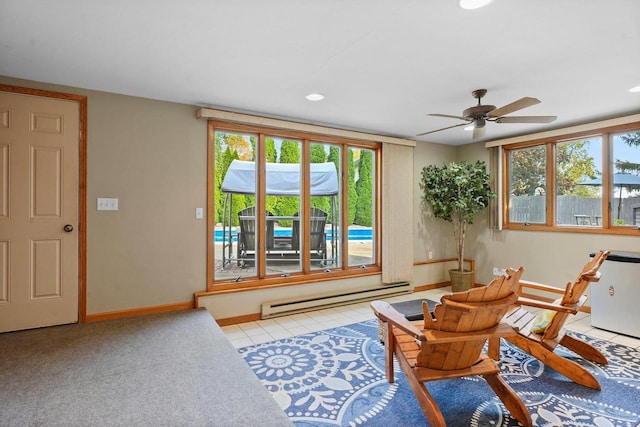 living area featuring ceiling fan, light tile patterned floors, a wealth of natural light, and a baseboard radiator