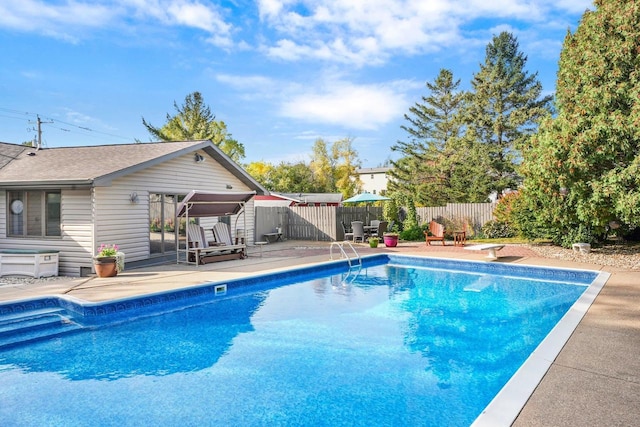 view of swimming pool featuring a diving board and a patio area