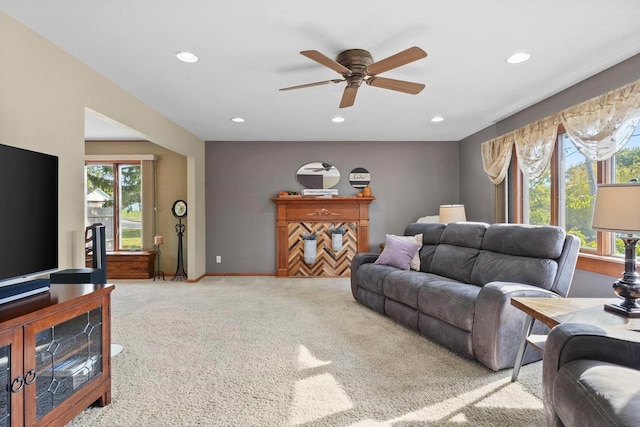 carpeted living room with a wealth of natural light and ceiling fan